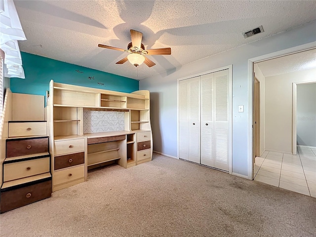 8346 Mattituck Cir, Orlando, FL 32829 - unfurnished bedroom featuring light carpet, a textured ceiling, a closet, ceiling fan, and light tile patterned floors