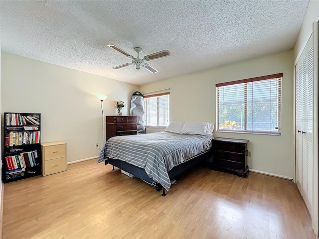 8346 Mattituck Cir, Orlando, FL 32829 - bedroom featuring light wood-type flooring, a textured ceiling, ceiling fan, and a closet