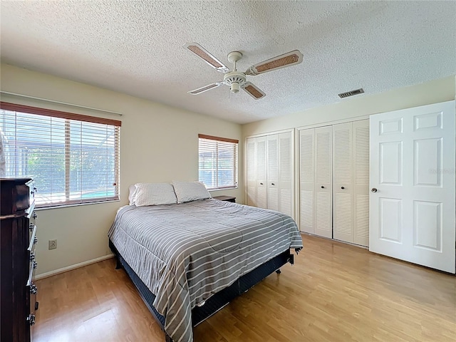8346 Mattituck Cir, Orlando, FL 32829 - bedroom with light wood-style flooring, a textured ceiling, multiple closets, and ceiling fan
