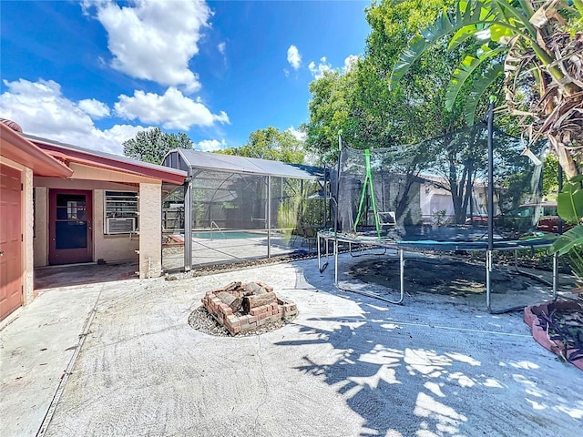 8346 Mattituck Cir, Orlando, FL 32829 - view of patio / terrace featuring a trampoline, an outdoor fire pit, and glass enclosure