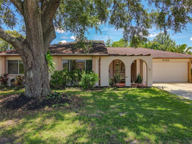 8346 Mattituck Cir, Orlando, FL 32829 - view of front facade featuring stucco siding, a garage, concrete driveway, and a front lawn