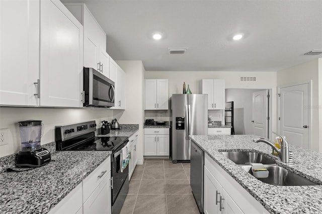 1792 Bull Hill Rd, Kissimmee, FL 34744 - kitchen featuring appliances with stainless steel finishes, white cabinetry, light stone counters, light tile patterned flooring, and recessed lighting