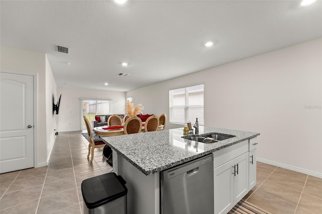 1792 Bull Hill Rd, Kissimmee, FL 34744 - kitchen featuring stainless steel dishwasher, light tile patterned floors, a kitchen island with sink, white cabinetry, and light stone countertops