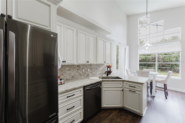 9285 Wickham Way, Orlando, FL 32836 - kitchen with freestanding refrigerator, dishwashing machine, dark wood finished floors, white cabinetry, and backsplash