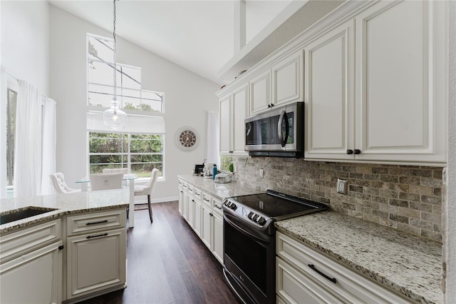 9285 Wickham Way, Orlando, FL 32836 - kitchen featuring range with electric stovetop, stainless steel microwave, high vaulted ceiling, tasteful backsplash, and dark wood-style floors
