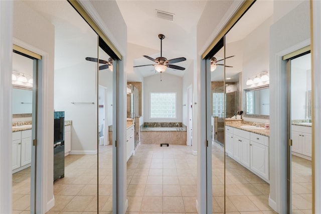 9285 Wickham Way, Orlando, FL 32836 - bathroom with two vanities, ceiling fan, a garden tub, tile patterned flooring, and vaulted ceiling