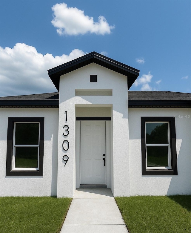 1309 Hillsborough Ln, Kissimmee, FL 34759 - view of exterior entry with stucco siding and roof with shingles