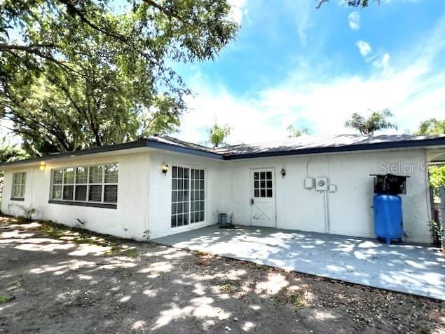 9148 Oakwood Dr, Lake Wales, FL 33898 - rear view of house featuring stucco siding and a patio area