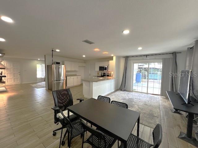 9148 Oakwood Dr, Lake Wales, FL 33898 - dining area with recessed lighting, light wood-type flooring, and a wood stove