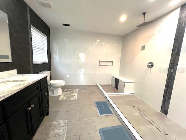 9148 Oakwood Dr, Lake Wales, FL 33898 - bathroom featuring vanity, tile patterned flooring, and walk in shower
