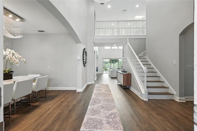 13924 Jomatt Loop, Winter Garden, FL 34787 - foyer with arched walkways, stairs, a high ceiling, a chandelier, and dark wood-type flooring