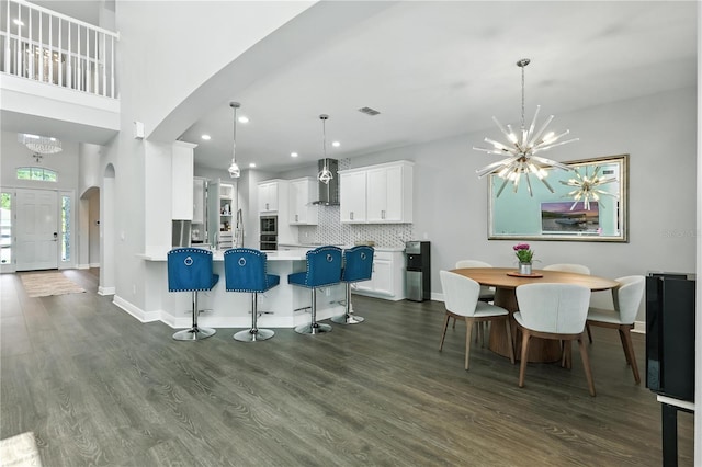 13924 Jomatt Loop, Winter Garden, FL 34787 - kitchen featuring wall chimney exhaust hood, arched walkways, a chandelier, white cabinets, and recessed lighting