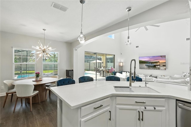 13924 Jomatt Loop, Winter Garden, FL 34787 - kitchen featuring stainless steel dishwasher, open floor plan, dark wood-style floors, light countertops, and decorative light fixtures