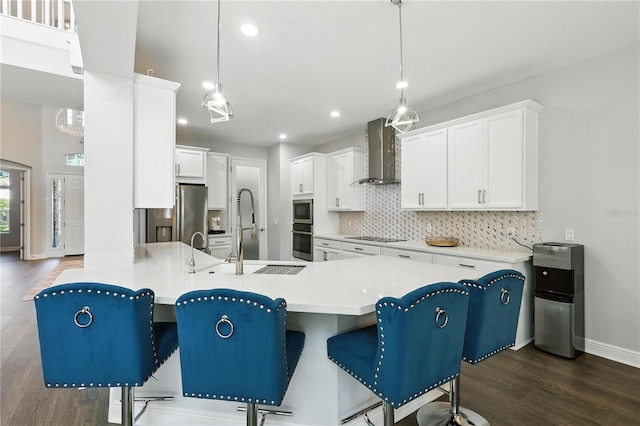 13924 Jomatt Loop, Winter Garden, FL 34787 - kitchen with wall chimney range hood, appliances with stainless steel finishes, dark wood-type flooring, backsplash, and a peninsula