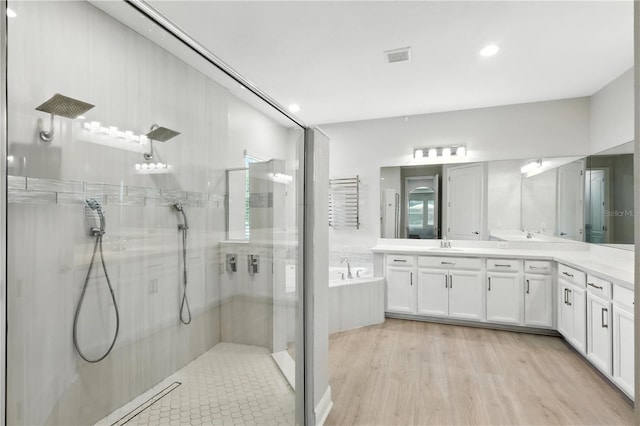 13924 Jomatt Loop, Winter Garden, FL 34787 - full bath with a stall shower, double vanity, a garden tub, wood finished floors, and recessed lighting
