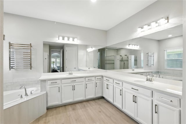 13924 Jomatt Loop, Winter Garden, FL 34787 - full bathroom featuring radiator, a garden tub, double vanity, and a stall shower
