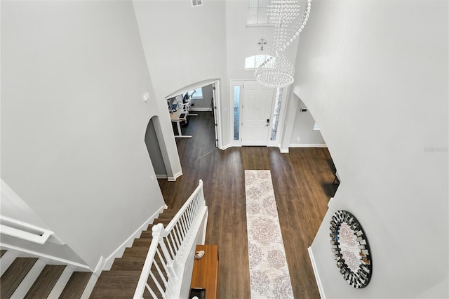 13924 Jomatt Loop, Winter Garden, FL 34787 - foyer entrance featuring arched walkways, a towering ceiling, stairway, a chandelier, and wood finished floors