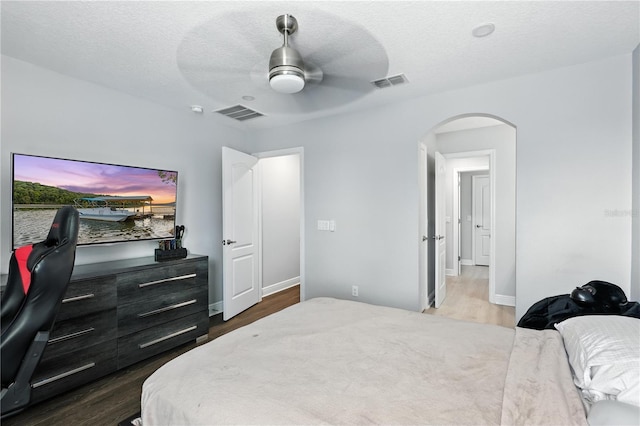 13924 Jomatt Loop, Winter Garden, FL 34787 - bedroom with arched walkways, dark wood-type flooring, a textured ceiling, and a ceiling fan