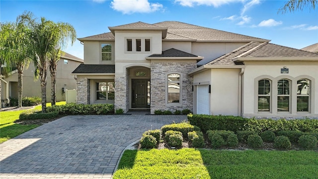 13924 Jomatt Loop, Winter Garden, FL 34787 - french country style house featuring stucco siding, an attached garage, stone siding, and decorative driveway