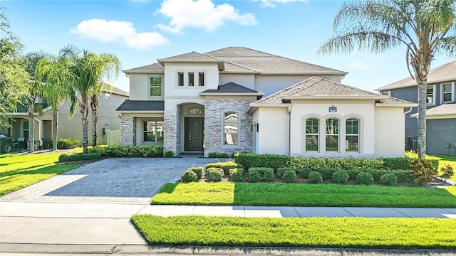 13924 Jomatt Loop, Winter Garden, FL 34787 - french country inspired facade featuring stucco siding, driveway, stone siding, and a front yard