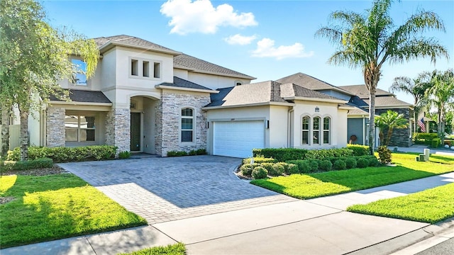 13924 Jomatt Loop, Winter Garden, FL 34787 - view of front of house featuring stucco siding, an attached garage, decorative driveway, stone siding, and a front yard
