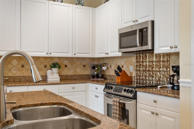 4709 Fox St, Orlando, FL 32814 - kitchen with appliances with stainless steel finishes, white cabinets, and dark stone counters