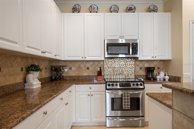 4709 Fox St, Orlando, FL 32814 - kitchen with appliances with stainless steel finishes, dark stone countertops, white cabinets, and backsplash