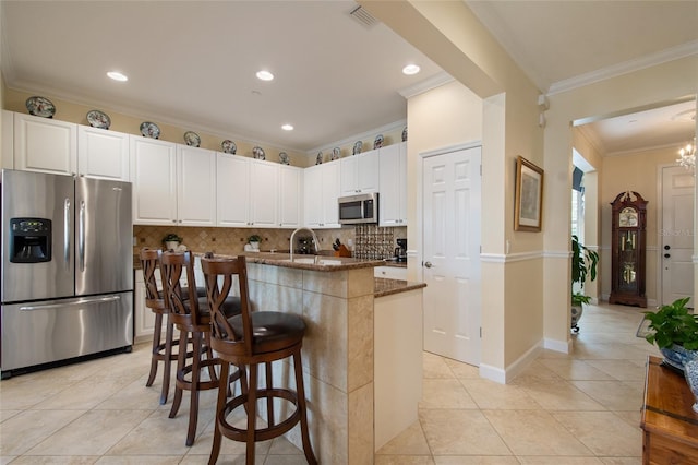 4709 Fox St, Orlando, FL 32814 - kitchen with stainless steel appliances, dark stone counters, light tile patterned flooring, tasteful backsplash, and ornamental molding