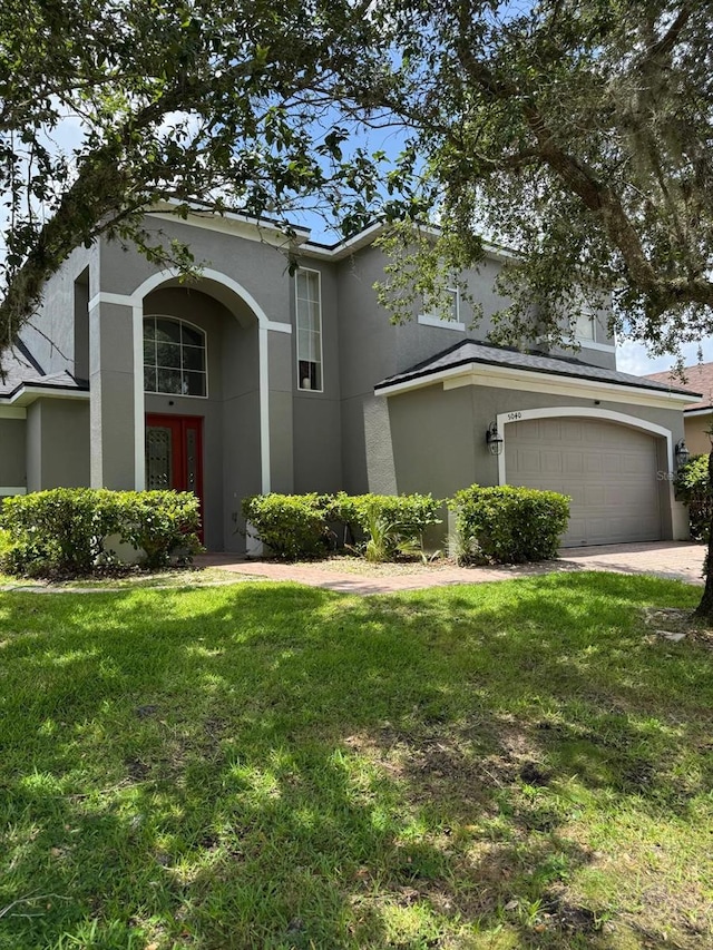 5040 Rock Rose Loop, Sanford, FL 32771 - traditional-style house with stucco siding, a front yard, an attached garage, and driveway