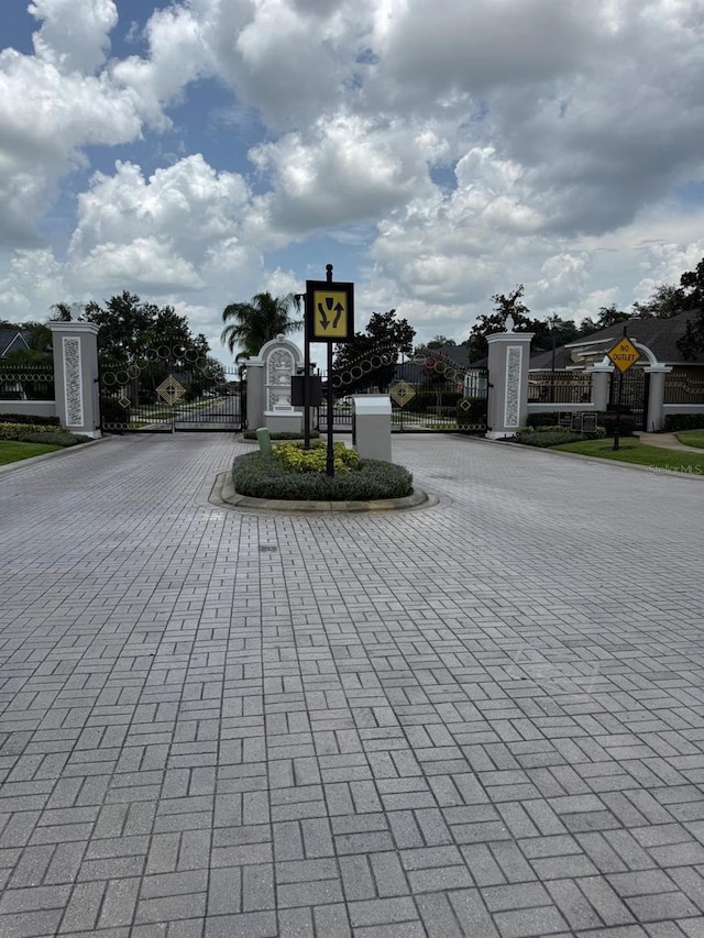 5040 Rock Rose Loop, Sanford, FL 32771 - view of street featuring traffic signs, a gate, curbs, and a gated entry