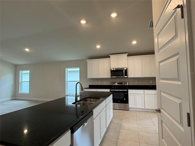 3891 Sagefield Dr, Harmony, FL 34773 - kitchen with appliances with stainless steel finishes, dark countertops, recessed lighting, and white cabinets