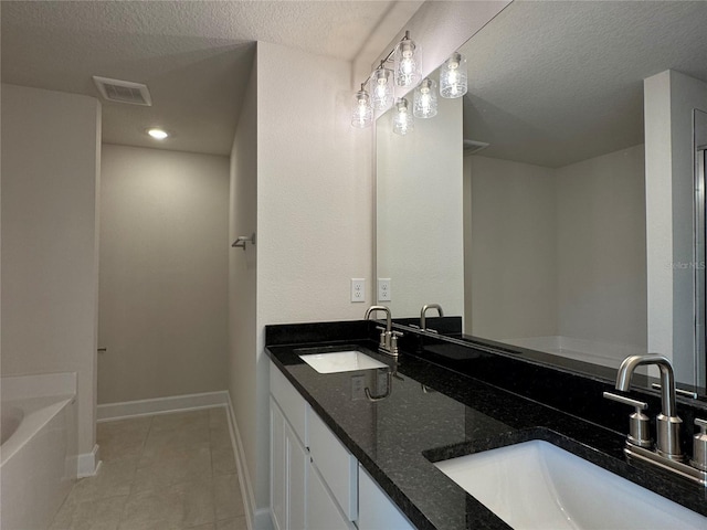 3891 Sagefield Dr, Harmony, FL 34773 - full bath featuring a garden tub, double vanity, a textured ceiling, and tile patterned floors