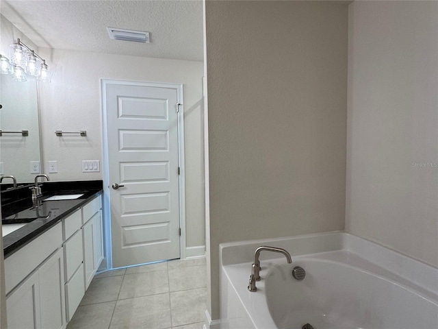 3891 Sagefield Dr, Harmony, FL 34773 - bathroom featuring tile patterned flooring, double vanity, a garden tub, and a textured ceiling