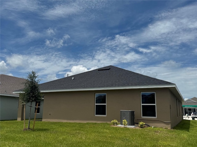 3891 Sagefield Dr, Harmony, FL 34773 - back of house featuring a shingled roof, stucco siding, and a yard