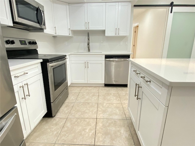 508 Sandtree, Palm Beach Gardens, FL 33403 - kitchen with stainless steel appliances, light countertops, white cabinetry, and light tile patterned floors