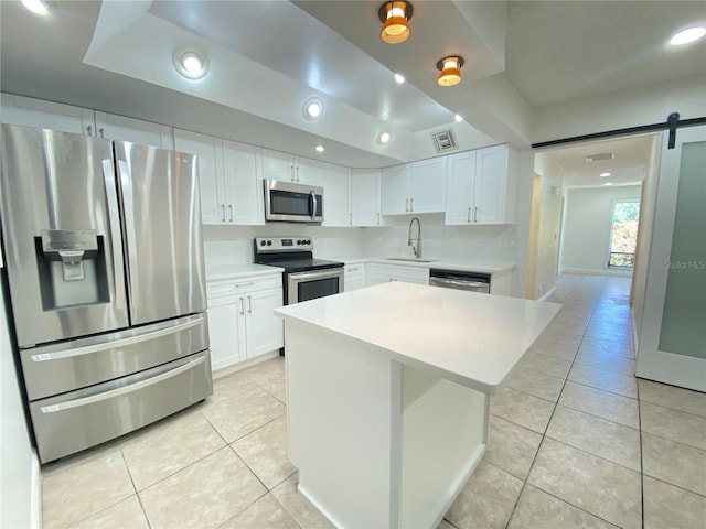 508 Sandtree, Palm Beach Gardens, FL 33403 - kitchen with appliances with stainless steel finishes, light tile patterned flooring, a barn door, white cabinets, and light countertops
