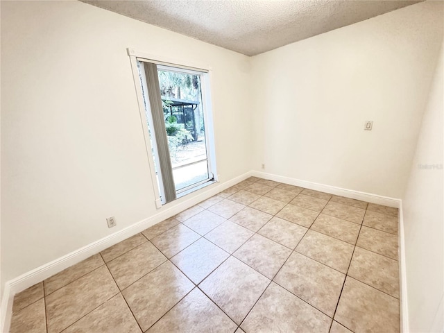 508 Sandtree, Palm Beach Gardens, FL 33403 - empty room with a textured ceiling and light tile patterned flooring