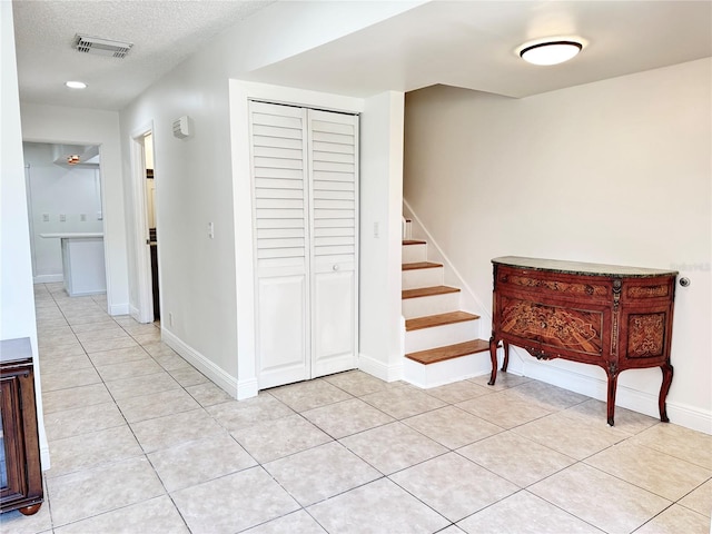 508 Sandtree, Palm Beach Gardens, FL 33403 - hall with stairway, light tile patterned floors, and a textured ceiling