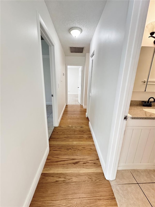 508 Sandtree, Palm Beach Gardens, FL 33403 - hall with a textured ceiling and light wood-style floors