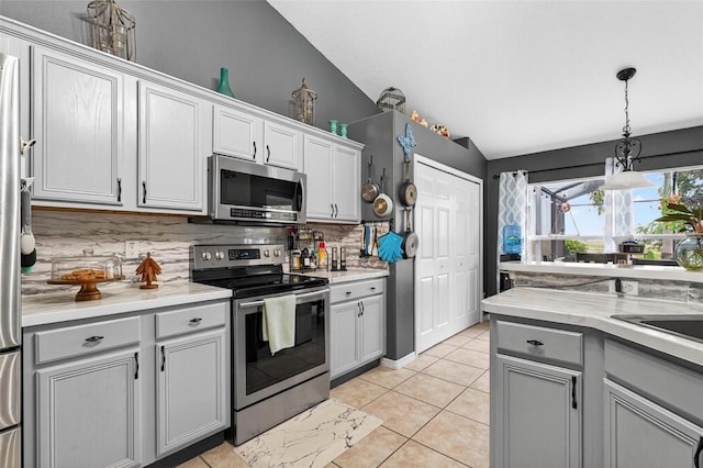 544 Lake Sumner Dr, Groveland, FL 34736 - kitchen with appliances with stainless steel finishes, tasteful backsplash, vaulted ceiling, light countertops, and decorative light fixtures