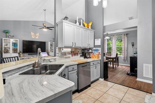 544 Lake Sumner Dr, Groveland, FL 34736 - kitchen with high vaulted ceiling, dishwasher, a ceiling fan, light tile patterned floors, and decorative backsplash