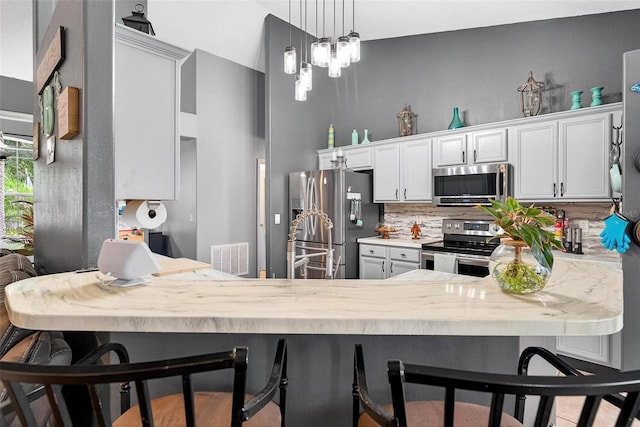 544 Lake Sumner Dr, Groveland, FL 34736 - kitchen featuring appliances with stainless steel finishes, backsplash, a peninsula, and decorative light fixtures