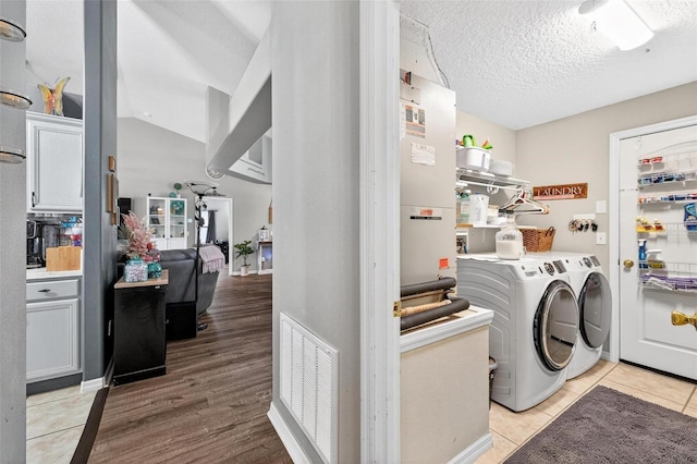544 Lake Sumner Dr, Groveland, FL 34736 - laundry area featuring washing machine and clothes dryer, light wood-style flooring, and a textured ceiling