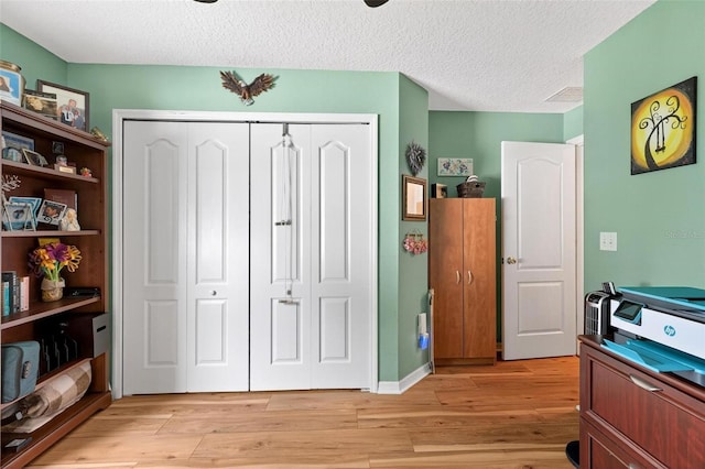 544 Lake Sumner Dr, Groveland, FL 34736 - bedroom featuring a closet, light wood-style floors, and a textured ceiling