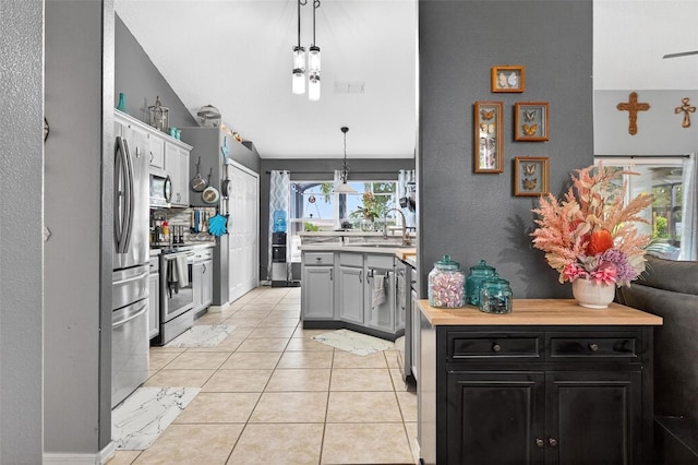 544 Lake Sumner Dr, Groveland, FL 34736 - kitchen with stainless steel appliances, light countertops, dark cabinets, hanging light fixtures, and light tile patterned flooring