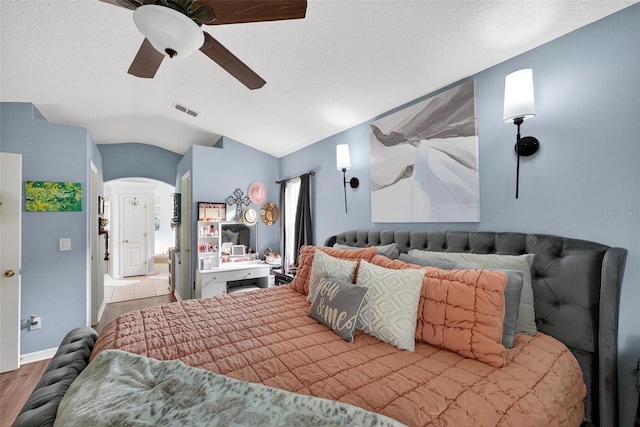 544 Lake Sumner Dr, Groveland, FL 34736 - bedroom featuring arched walkways, vaulted ceiling, a ceiling fan, and wood finished floors