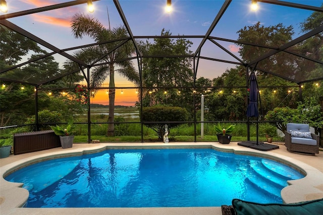 544 Lake Sumner Dr, Groveland, FL 34736 - pool at dusk featuring an outdoor pool, glass enclosure, and a patio area