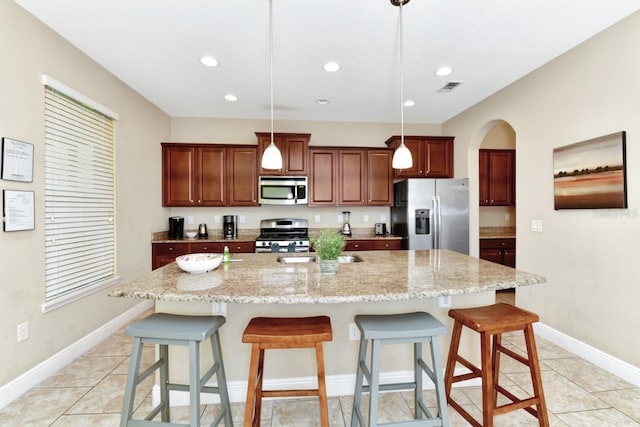 4123 Oaktree Dr, Davenport, FL 33837 - kitchen with appliances with stainless steel finishes, a kitchen bar, recessed lighting, a large island with sink, and hanging light fixtures