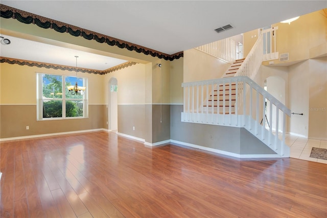 2794 Cullens Ct, Ocoee, FL 34761 - unfurnished living room with a chandelier, wood finished floors, stairway, and arched walkways