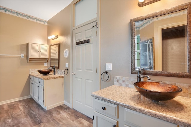 2794 Cullens Ct, Ocoee, FL 34761 - full bathroom featuring wood finished floors, two vanities, and tasteful backsplash